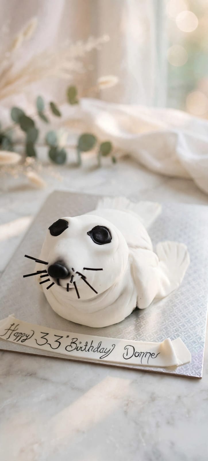 Sculpted white harp seal cake with a Happy 33rd Birthday banner