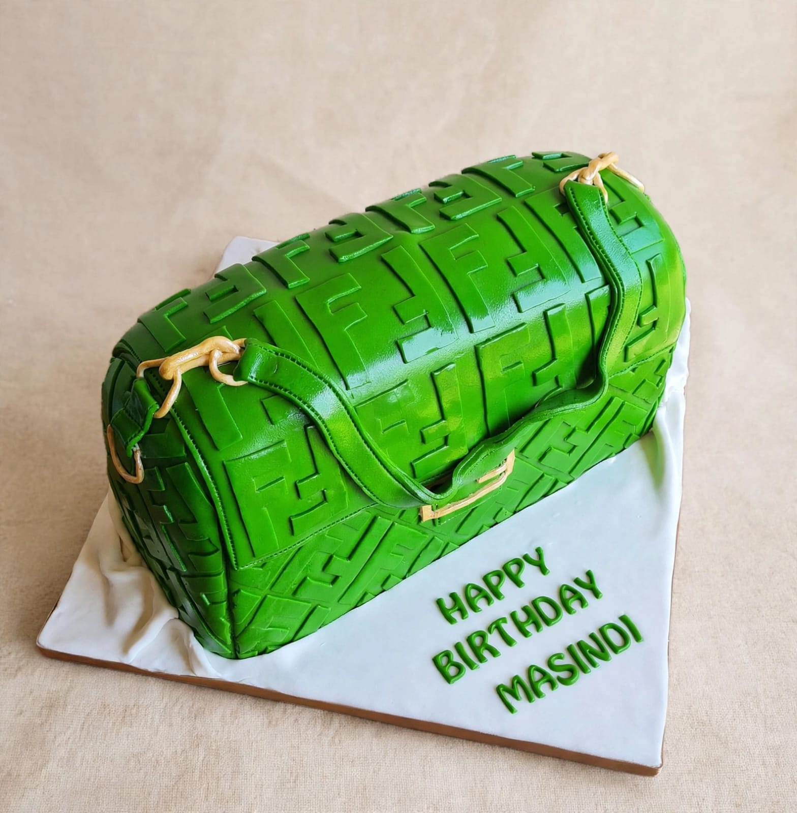 Sculpted green Fendi handbag cake with monogram print and gold hardware