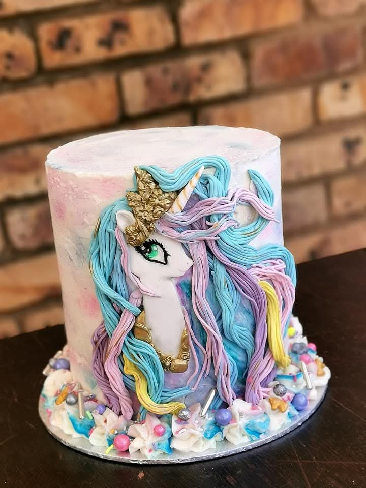 Unicorn birthday cake with pastel mane and gold horn