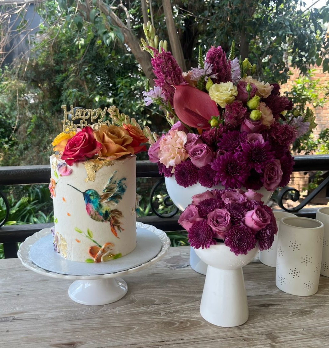 Hand-painted hummingbird cake with fresh roses and gold leaf